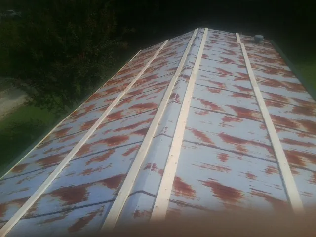 Rusted metal roof panels with new wood purlins before replacement — Storm Damage Roof Repair in Barrytown by Roofing Brothers