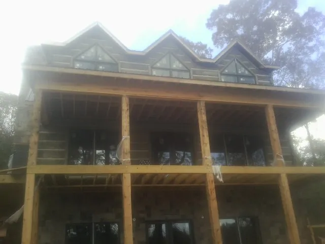 Dormers and porch framing on a large log home under construction — Roof Coating work by our crew in Barrytown