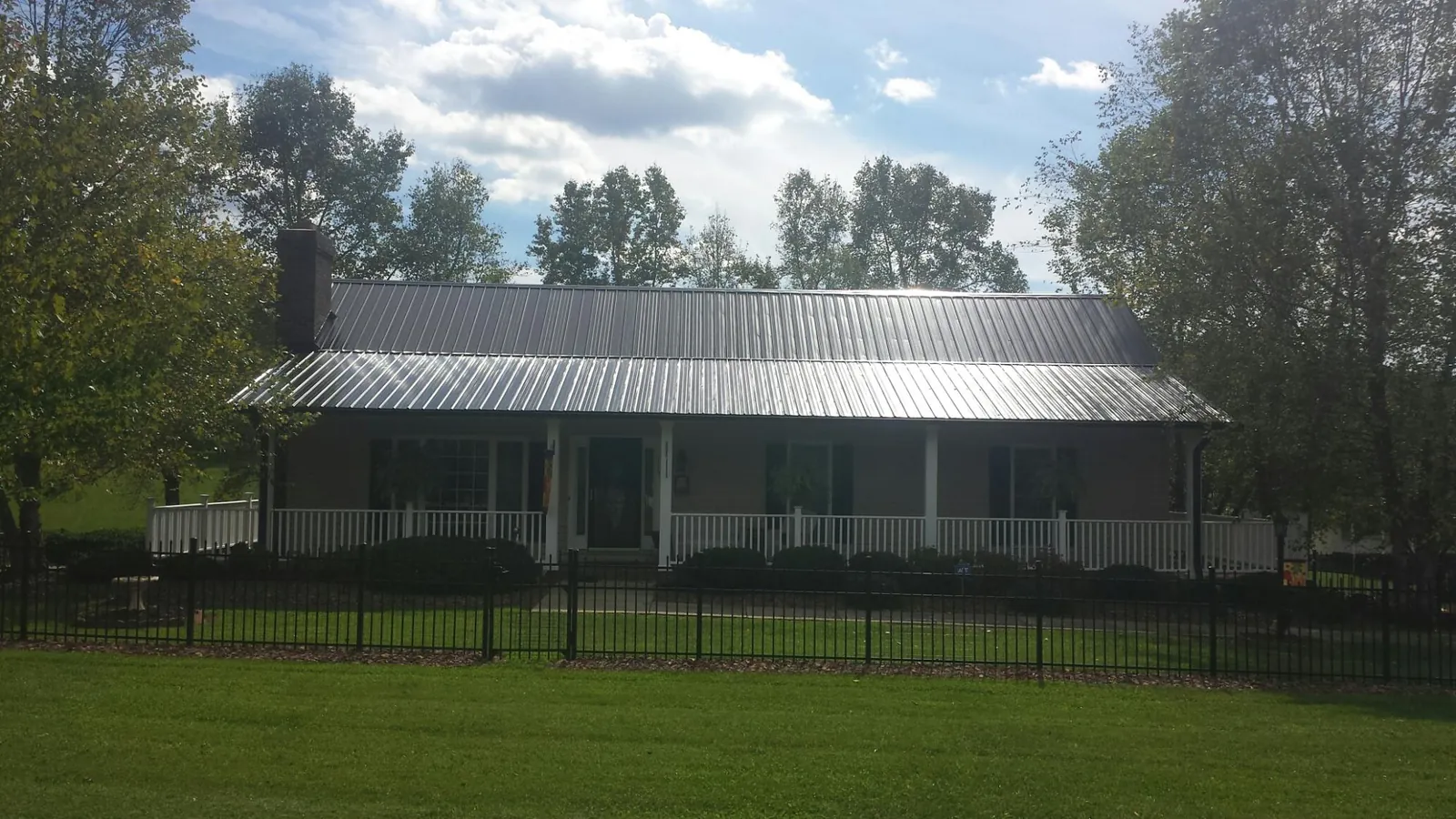 Gray metal roof on a brick ranch with a full width front porch — Gutter Guard Installation work by our crew in Barrytown