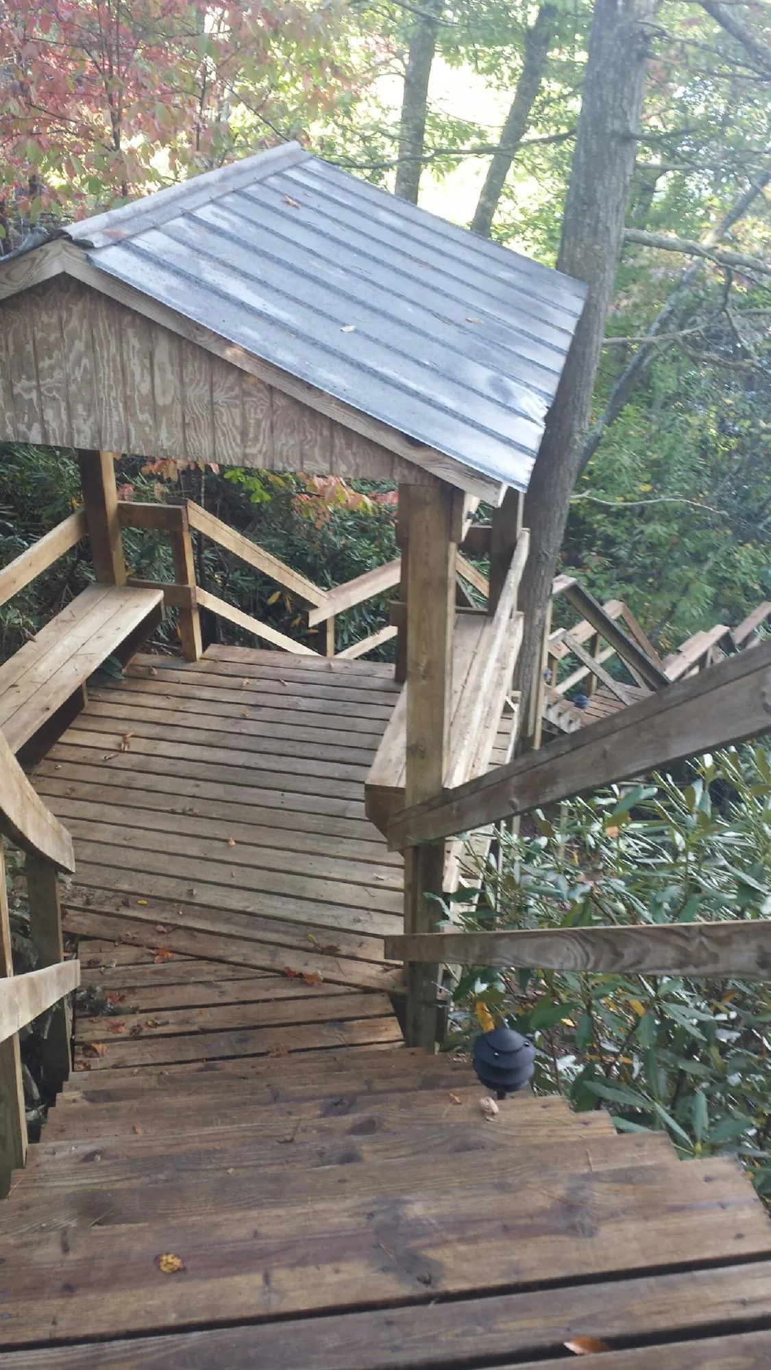 Metal roofed shelter over wooden steps on a wooded walkway — Skylight Repair & Installation work by our crew in Barrytown